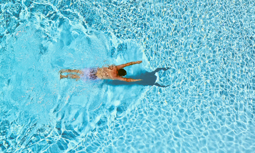 Clean pool with a man diving in